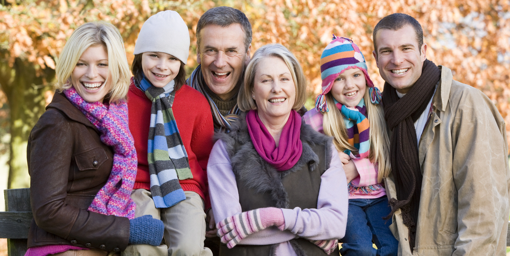 family dressed in warm clothes in front of fall background